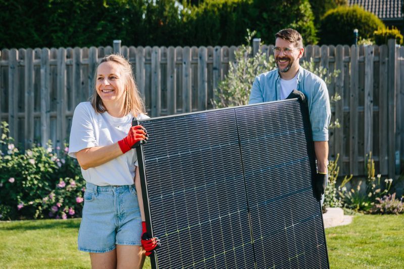 Zwei Menschen tragen Solarpanel