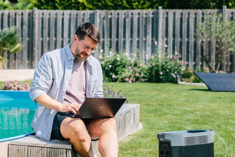 Mann in Garten mit EcoFlow Speicher